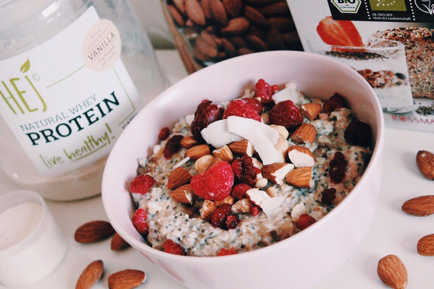 protein porridge mit gefrorenen beeren, kokosraspeln und mandeln